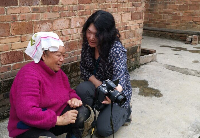 Reese 和被访村民交流。她的照片，让老人眉开眼笑。