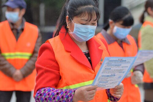 正在閱讀防疫資訊的清潔工人。