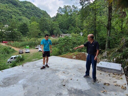 村民在向樂施會工作人員介紹新修建好的水窖(攝:筆者)