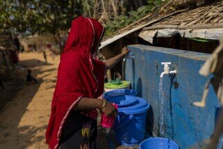 Khaleda collects safe drinking water from a nearby collection point. (Mushfiqul Alam/Oxfam)