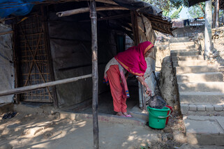 Abita throws her home waste into the green bin outside her house. Separated by colour, she knows which type of waste goes into which basket. (Mushfiqul Alam/Oxfam)