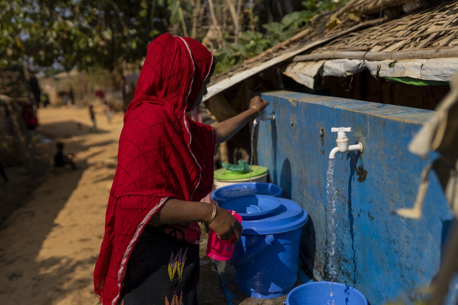 Khaleda collects safe drinking water from a nearby collection point. (Mushfiqul Alam/Oxfam)