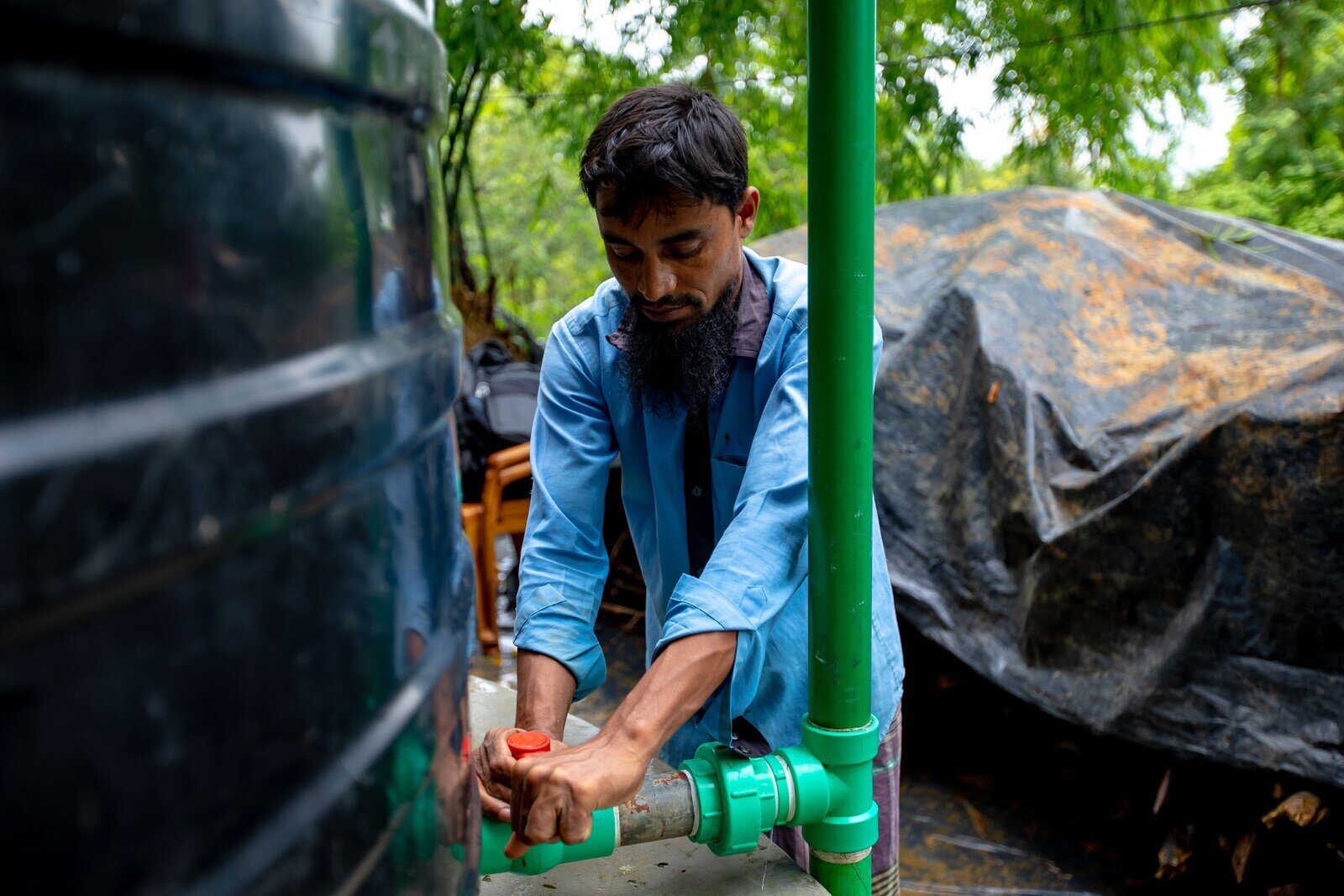 Khairul Bashar works on routine maintenance of the water pipes connected to the solar-powered water system. (Jubair Bin Iqbal/Oxfam)