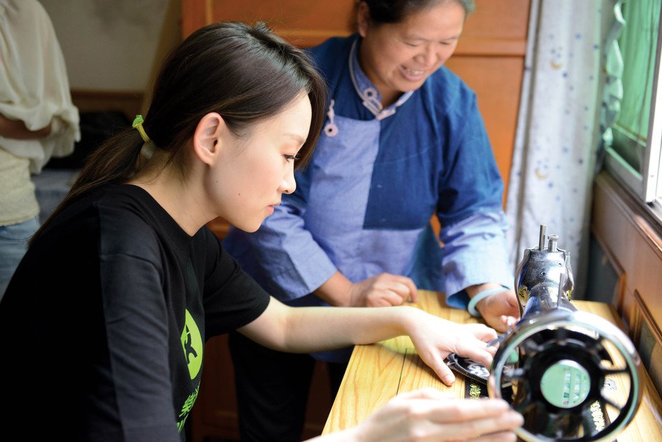 乐施大使王菀之在「云南连心」的「绿工坊」妇女生计小组，向柏大姐学习布依族传统针线手艺。