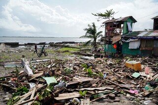 Residents walk past a house damaged during Typhoon Phanfone in Tacloban, Leyte province in the central Philippines on 25 December 2019. Typhoon Phanfone pummelled the central Philippines on Christmas Day, bringing a wet and miserable holiday season to millions in the mainly Catholic nation. (Photo: Bobbie Alota / AFP)