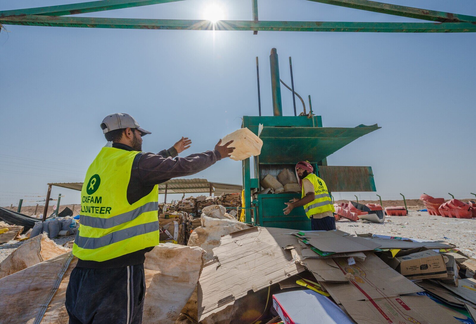 The Recycling Project Centre in Zaatari Refugee Camp. Oxfam introduced a solid waste management and recycling project in three of the camp’s 12  districts. The project, which was well-received by Zaatari residents, is being scaled up and will be introduced in all districts of the camp.  Syrian refugees working in the recycling centre. They work seven hours a day for a wage of seven Jordanian Dinars. The workers are separating different materials at the centre. (Photo: Poon Wai Nang/Oxfam)