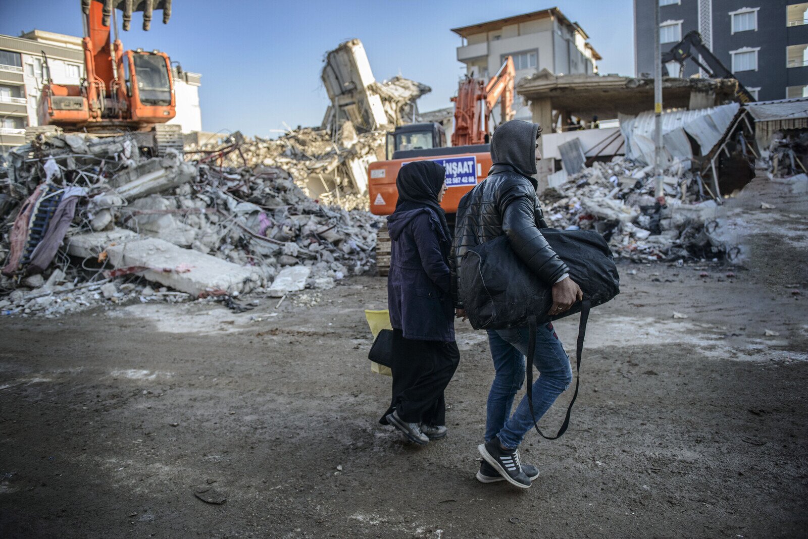 Two local residents gathering belongings from their destroyed home, before joining to the thousands of displaced survivors of the disaster.