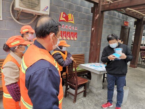 除了派發防疫用品,還有教導清潔工正確佩戴口罩的方法。